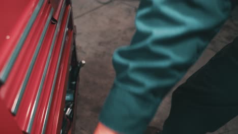 mechanic browsing in a toolbox full of adjustable wrenches, twezeers, pliers