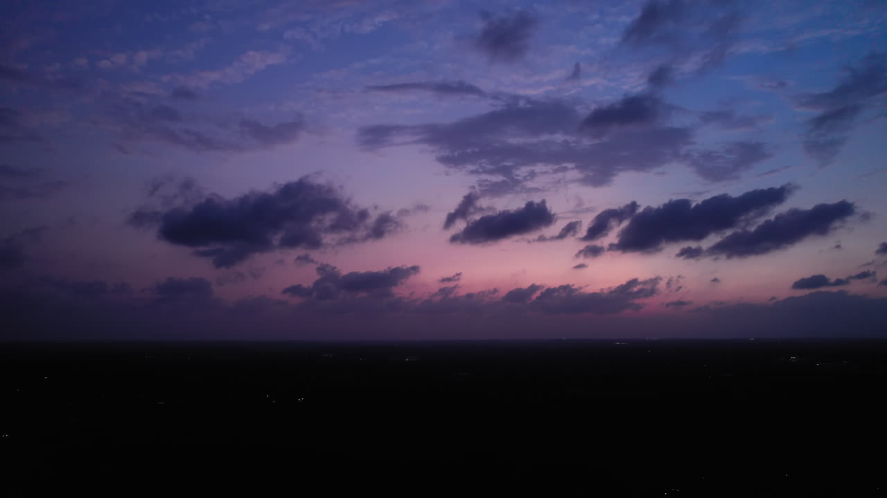 Colorful Blue Hour cloudscape, clouds drifting across the sky over an Austin, Texas suburb