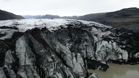 Island-Gletscher-Drohne-Fliegt-über-Den-Rand-Des-Gletschers,-Wo-Sie-Auf-Die-Gletscherlagune-Trifft