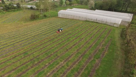 aerial view of a tractor farming in an agricultural field