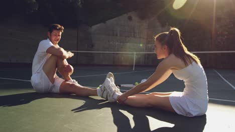 woman and man playing tennis on a sunny day