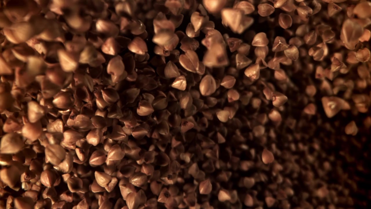 Grani di grano saraceno che cadono al rallentatore