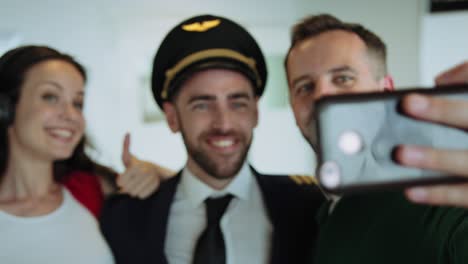 happy couple making selfie with pilot at airport lounge. cinematic shot on red camera.