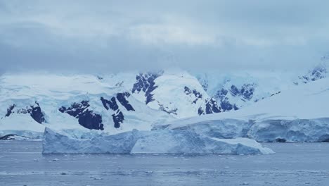 Icebergs-and-Mountains-Scenery-with-Glacier-and-Ice-in-Antarctica-Landscape-Scene,-Global-Warming-and-Climate-Change-in-Coastal-Ocean-and-Sea-Water-on-Coast-of-Antarctic-Peninsula-in-Winter