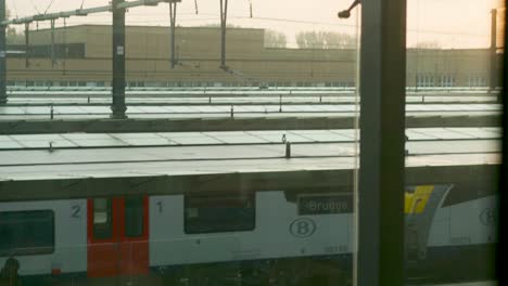 a passenger train leaving bruges railway station in belgium