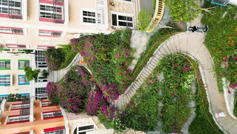vertical - tourists at thang rong stairs through colorful apartment buildings in sunset town, phu quoc, vietnam. drone shot