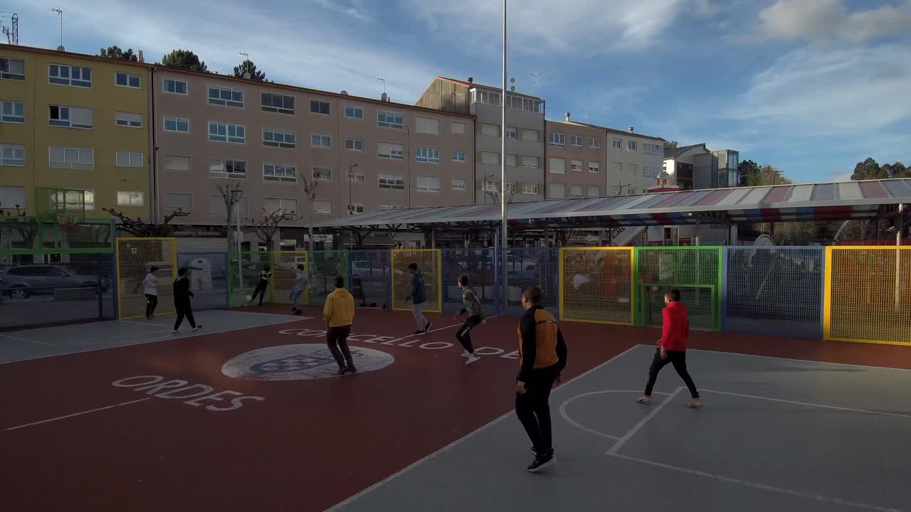 Group Of Teenage Boys Playing Soccer In Urban Playground In Ordes, Spain