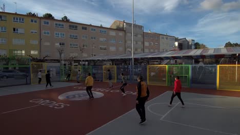 group of teenage boys playing soccer in urban playground in ordes, spain