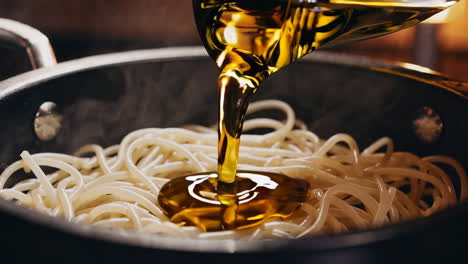 pouring olive oil on spaghetti