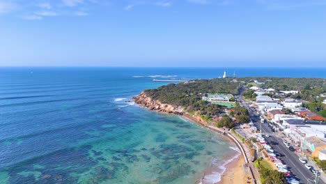 aerial footage captures point lonsdale's stunning coastline, showcasing clear waters, sandy beaches, and coastal vegetation under bright daylight