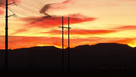 silhouette of high tension power transmission lines during sunset, aerial