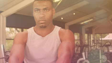 animation of glowing spots over strong man exercising in gym