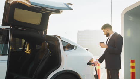 hombre cargando un suv eléctrico en una estación de carga