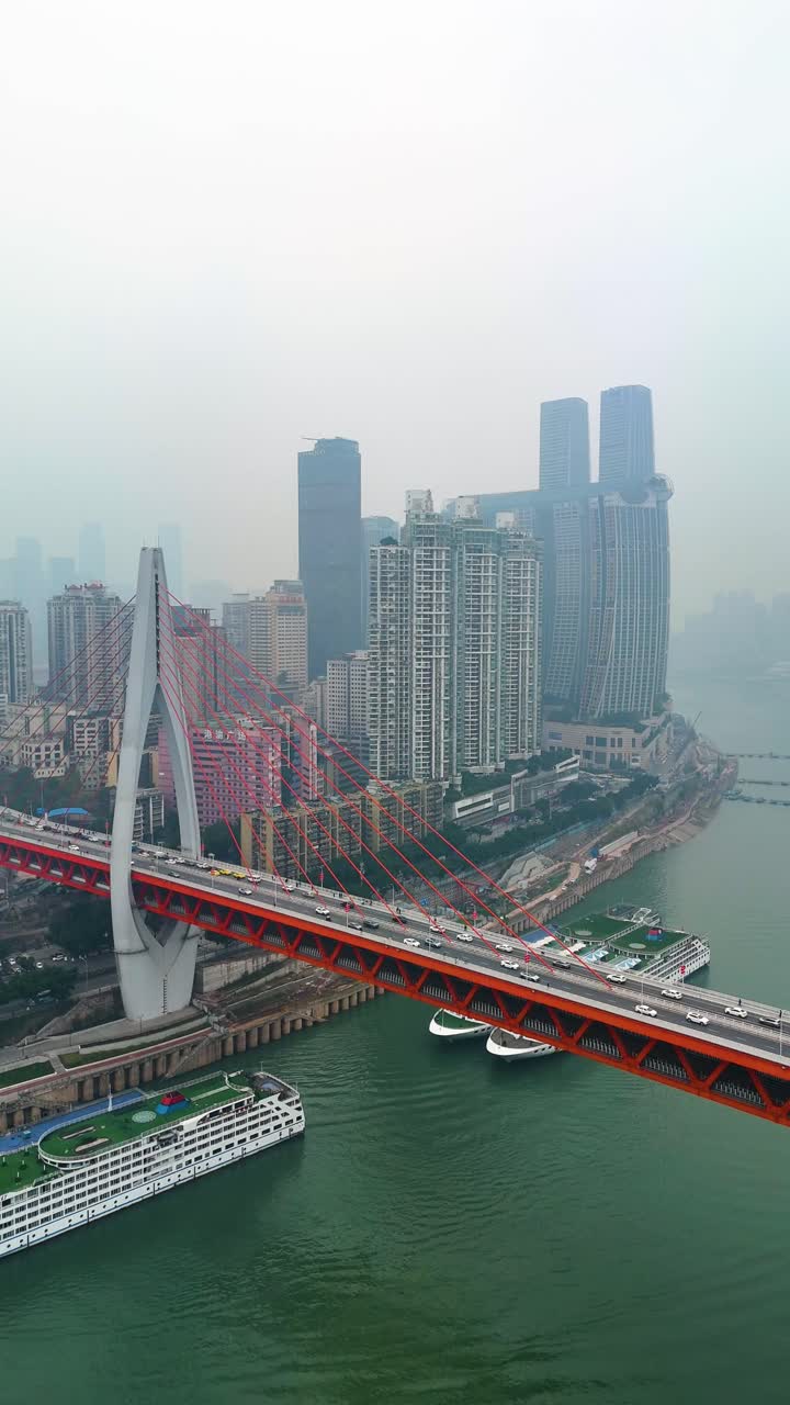 Vertical crane up drone shot of the Twin River Bridges with train and cars above Yangtze River during the day in Chongqing, Yuzhong District, China