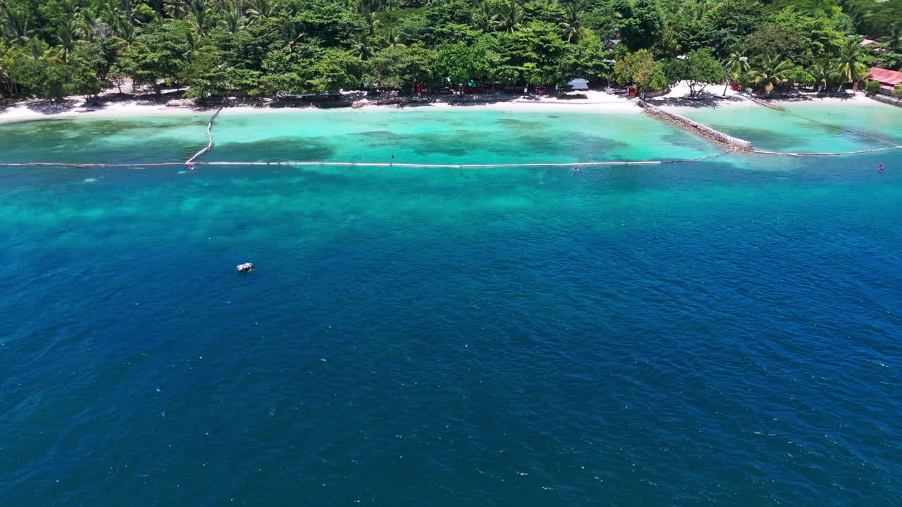 Top-down drone view of a tropical Philippine resort, showing clear blue water, white sand beach, and coastal villas—ideal for travel and tourism storytelling