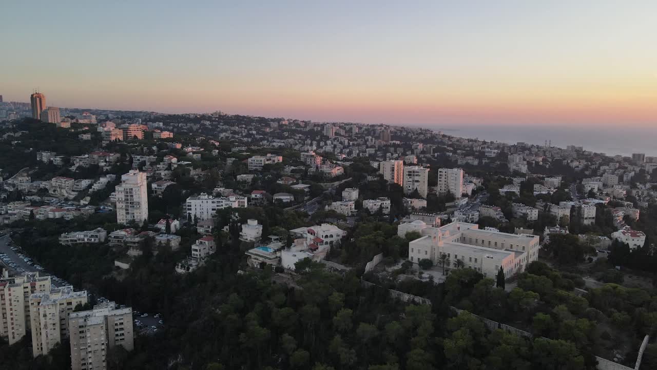 vista aérea ascendente de una ciudad llena de edificios y árboles al amanecer, haifa, israel
