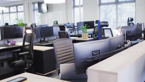 General-view-of-empty-modern-office-with-multiple-computers,-slow-motion