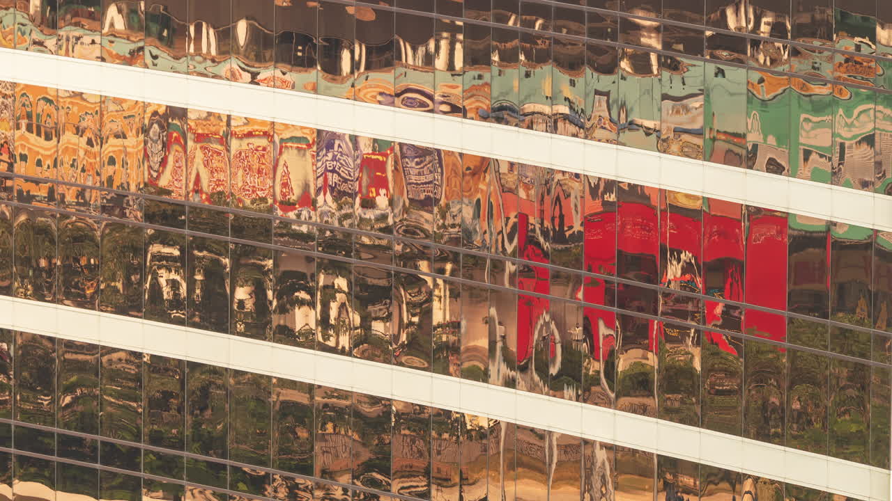 Reflejos coloridos en la fachada de cristal de un edificio moderno.