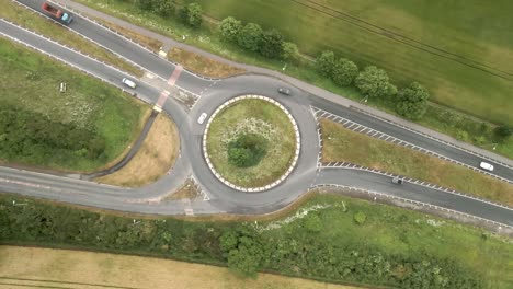 4K-descending-aerial-footage-of-a-junction-on-the-A64-near-Scarborough-with-cars-and-trucks-and-green-countryside