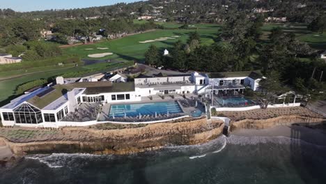 legendary pebble beach golf course and resorts at water's edge, aerial view panning