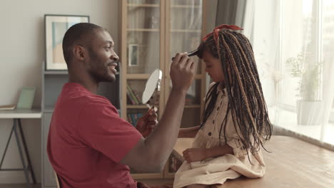 father and daughter playing with makeup