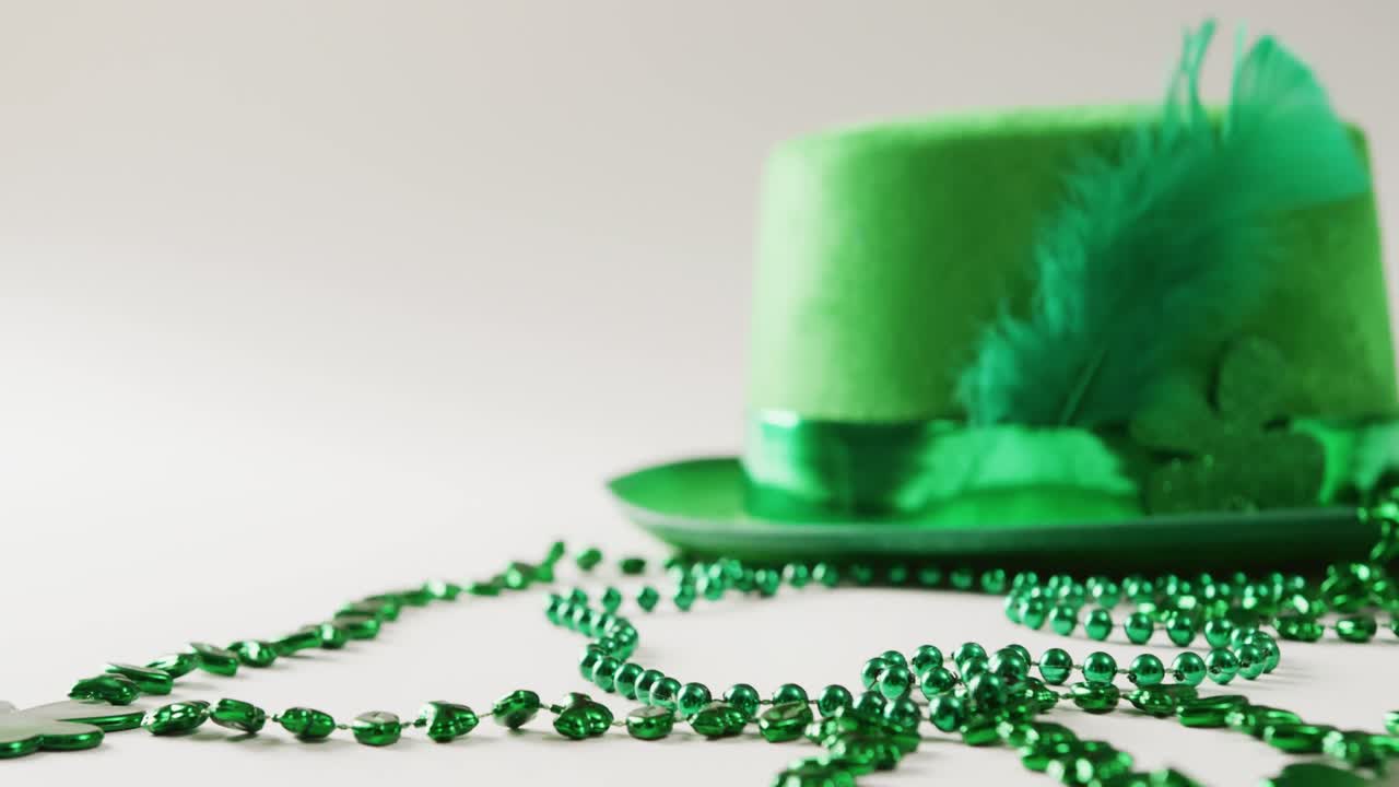 Video of st patrick's green hat and necklace with copy space on white background
