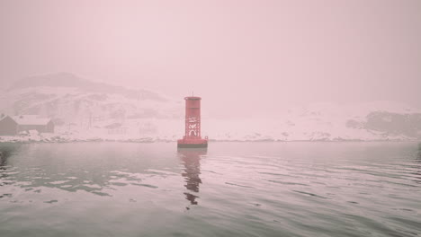 red buoy in a snowy landscape