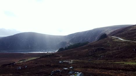 Aerial-drone-shot-rising-up-passing-over-the-scenic-landscape-surrounded-by-the-beautiful-Wicklow-Mountains-in-Dublin,-Ireland