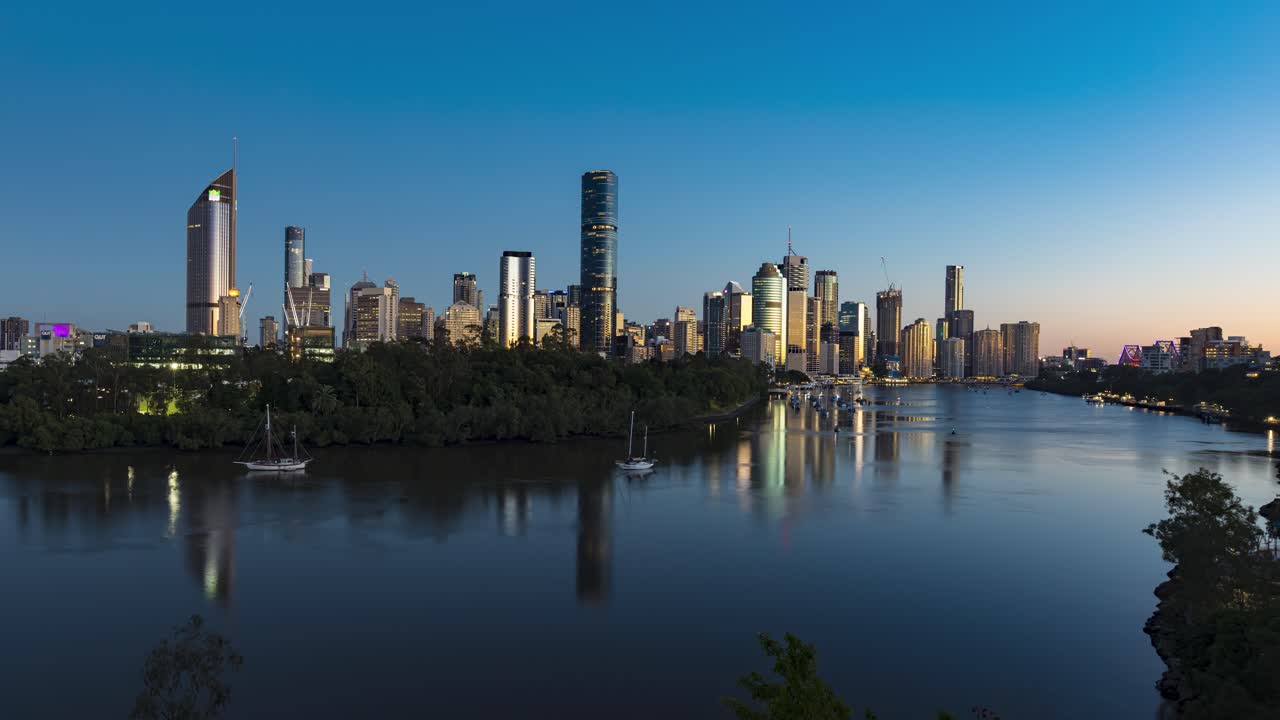 Tidsforkortet optagelse fra nat til dag af daggryet over Brisbane-floden med byens skyline.