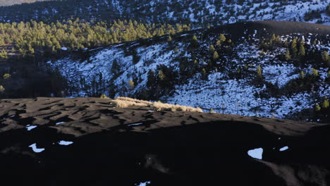 duna de arena negra con valle nevado de montaña en el cráter de la puesta del sol, asta de bandera - toma aérea de drones
