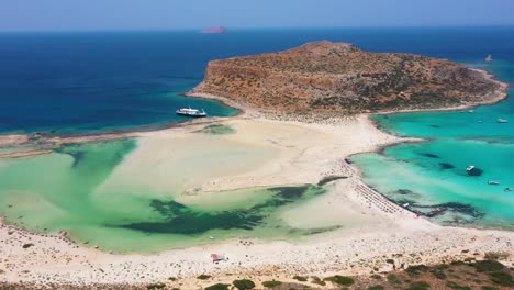 aerial revealing balos beach and lagoon with turquoise water, mountains and cliffs in crete, greece