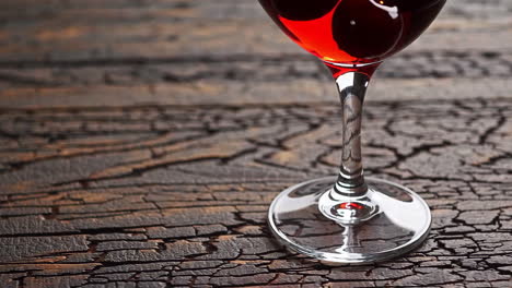 a glass of red wine or cocktail on a rustic wooden table