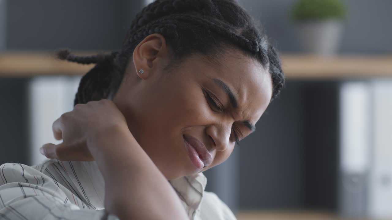 Woman experiencing neck pain in the office