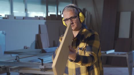 Carpenter-master-examining-raw-wood.