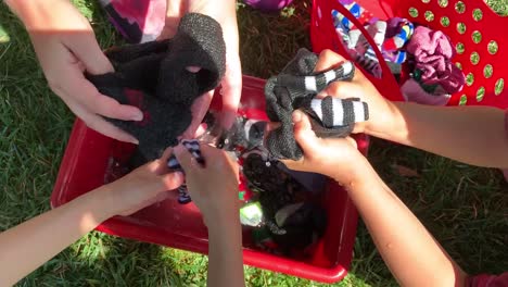 Small-hands-working-together-as-a-team-hand-wash-and-squeeze-water-out-of-soapy-socks