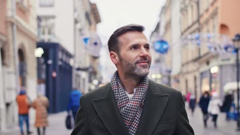 Smiling-man-with-shopping-bags-walking-down-the-city-street