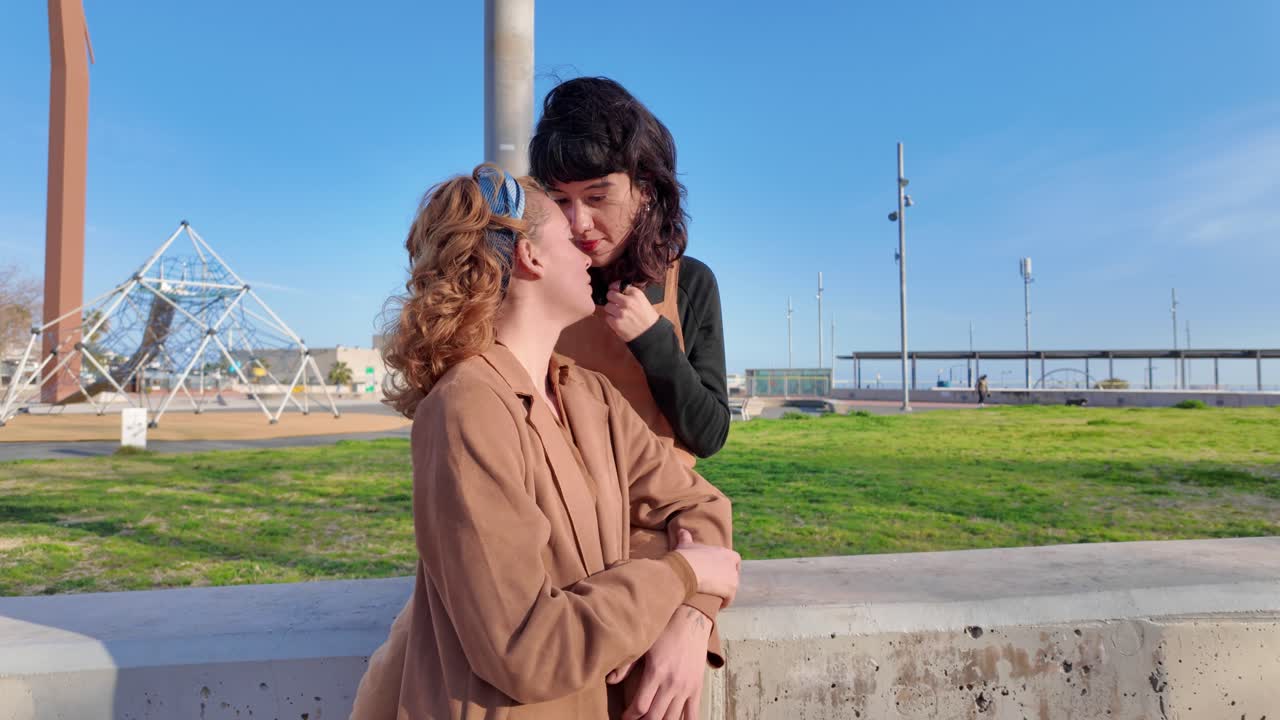 Two women kissing in a park