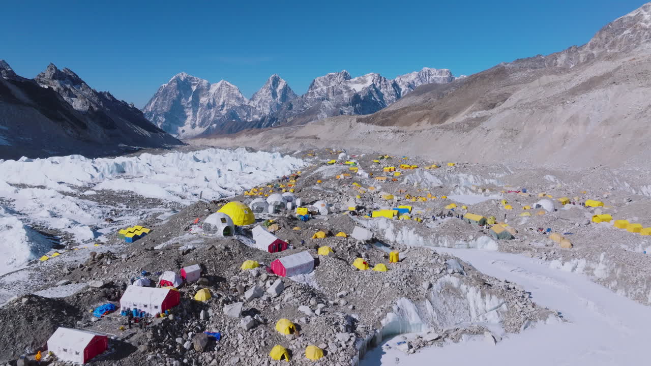 Drone view of Everest Base Camp with yellow climbers' tents forming a cultural hub. Shiny weather enhances Nepal's heavenly mountain tourism, mountain ranges shines with pride in Nepal