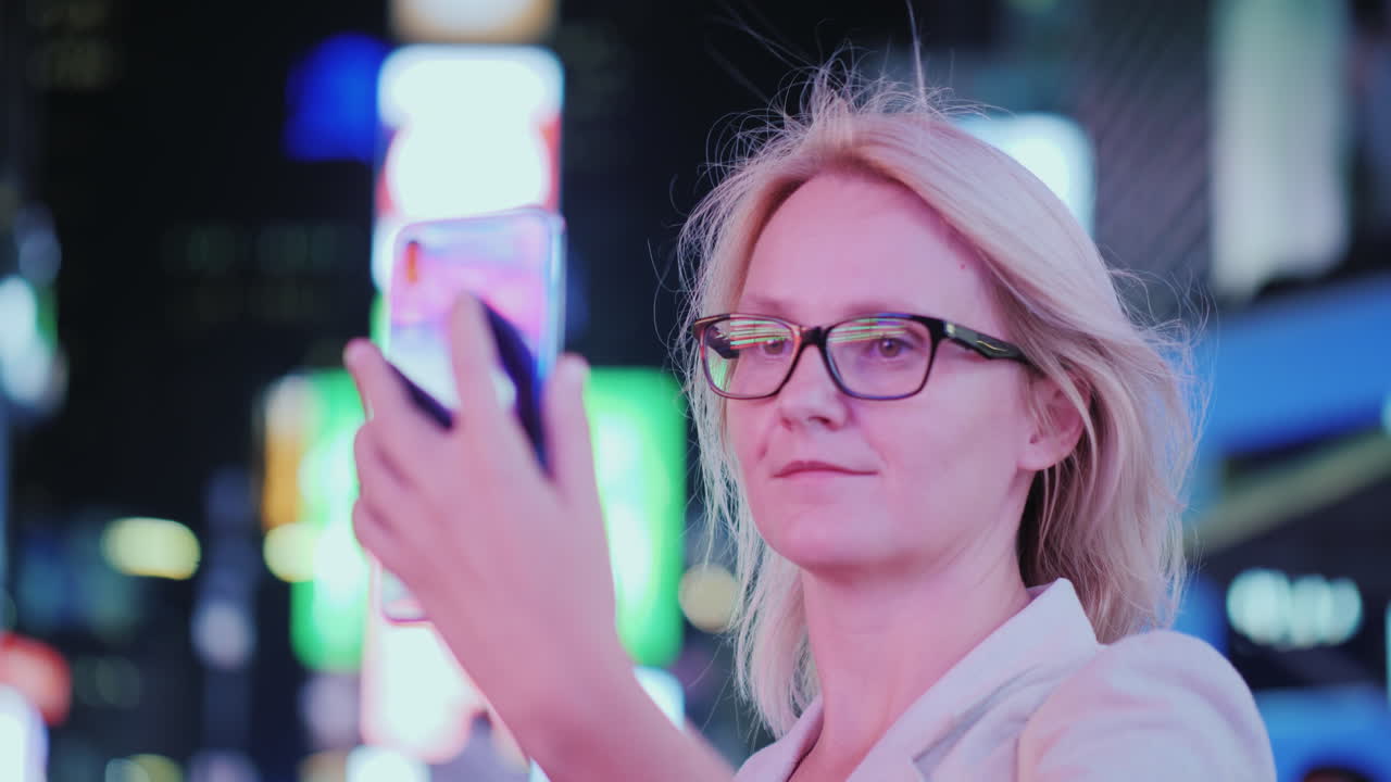 retrato de una mujer atractiva tomando fotografías de lugares de interés en times square se encuentra en el fondo