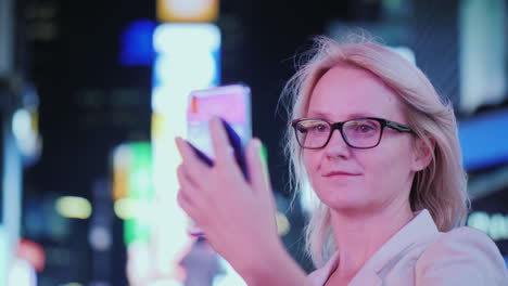 portrait of an attractive woman taking pictures of sights in times square it stands on the backgroun