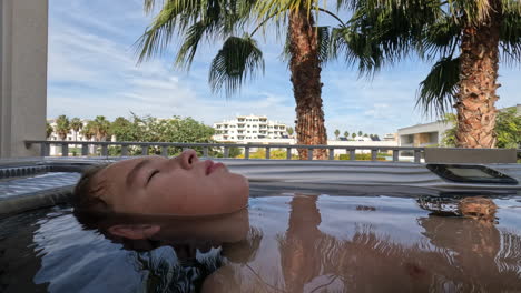 un niño relajándose en una bañera de agua caliente.