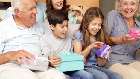 happy extended family opening gifts on the couch