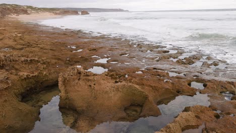 ocean waves hitting rock pools on a beach