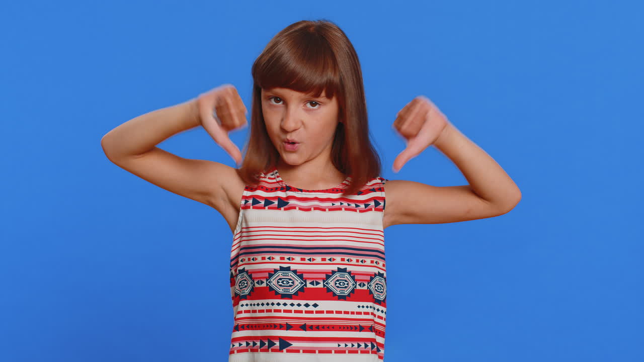 화를 내는 십대 전 소녀 엄지 손가락을 내리고, 나쁜 일을 싫어하고, 승인하지 않고, 불만족스러운 피드백