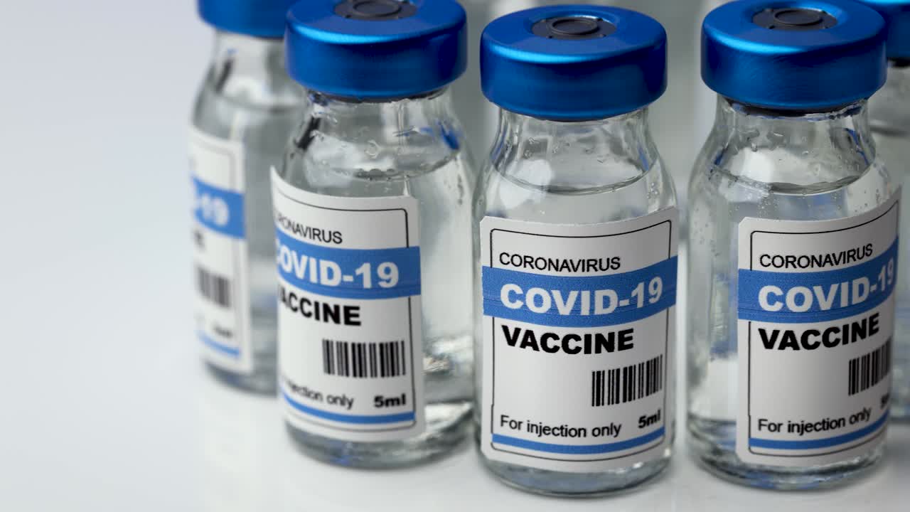 covid-19 vaccine - coronavirus vaccination bottles. injection vials turning