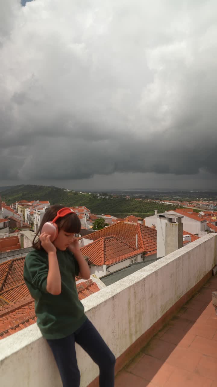 Girl with headphones on a rooftop in Portugal