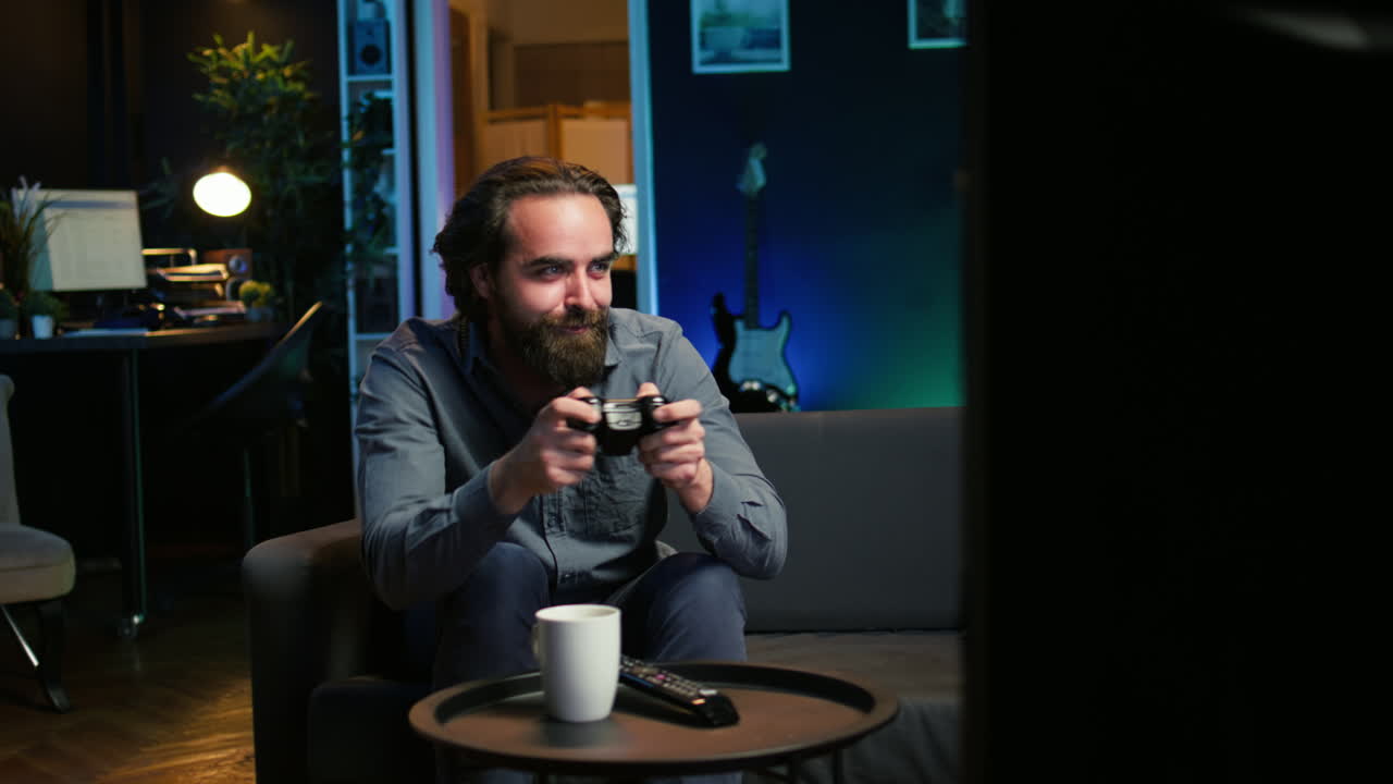 초점을 맞춘 남자가 네온 조명으로 조명된 집에서 비디오 게임을 하고 있습니다.