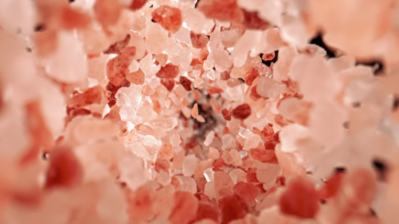 Himalayan pink salt is fallingin a super slow motion. Pink Himalayan salt is up to twenty times more expensive than table or sea salt. Shot on super slow motion camera 1000 fps