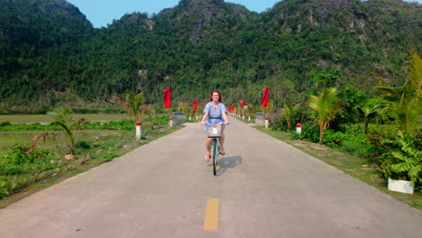 riding bicycle along the rural fields in viet hai village in cat ba island, vietnam.