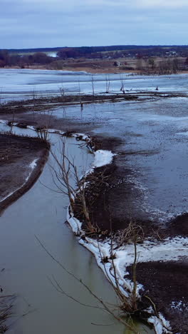 Ecology in danger. Dirty lake with polluted water in the countryside. Ecological disaster. Environmental problems. Aerial view. Vertical video